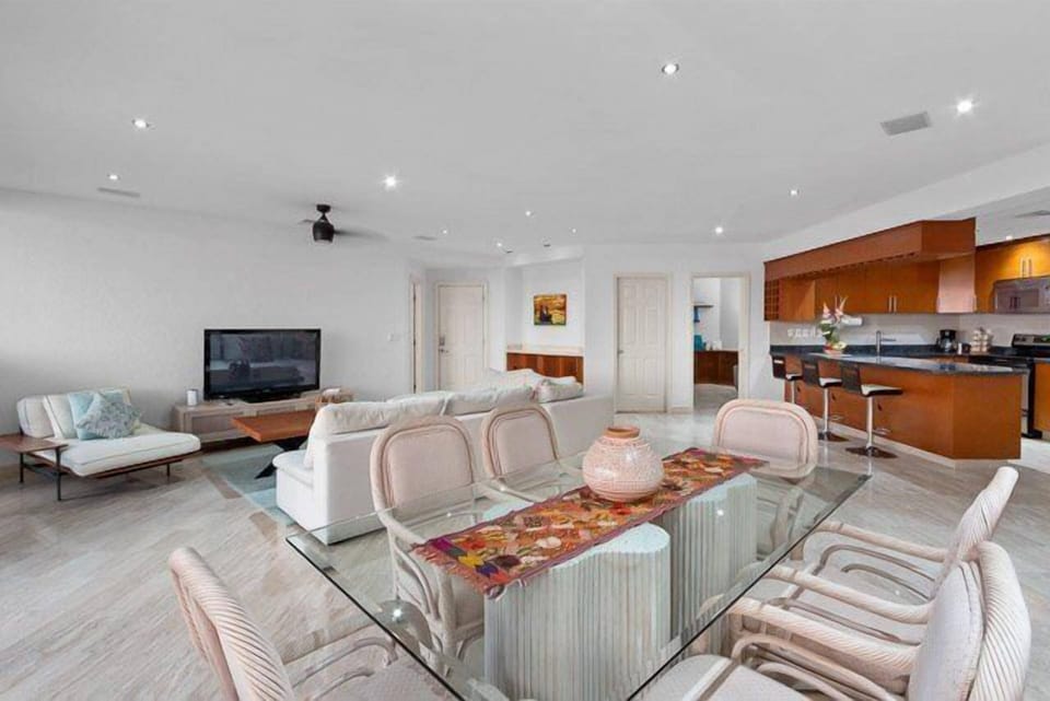 The living room has a comfortable l-shaped couch, ocean views, and a flat-screen TV