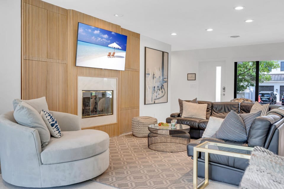 Spacious main living area features ample comfortable seating, smart TV, fireplace, while providing front to back views of the outdoor paradise.