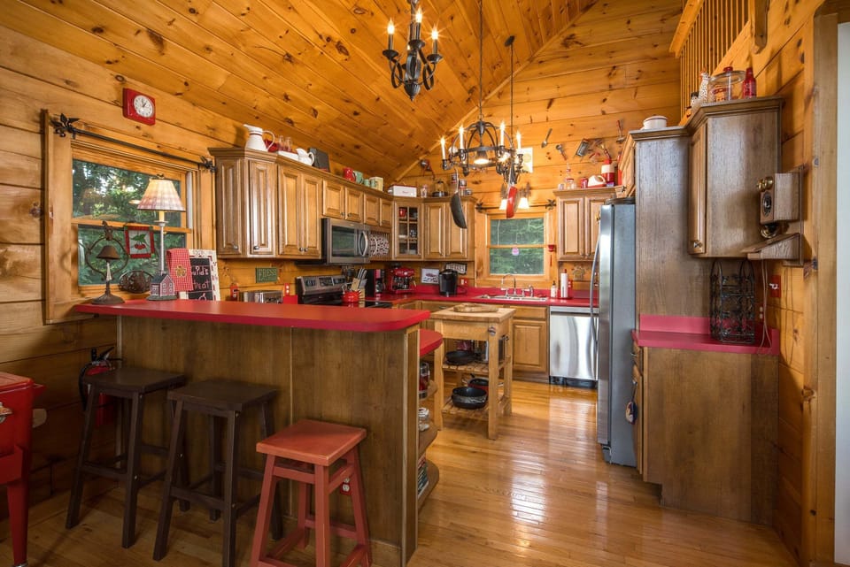 Fully equipped kitchen with warm wood cabinetry and bar seating for three