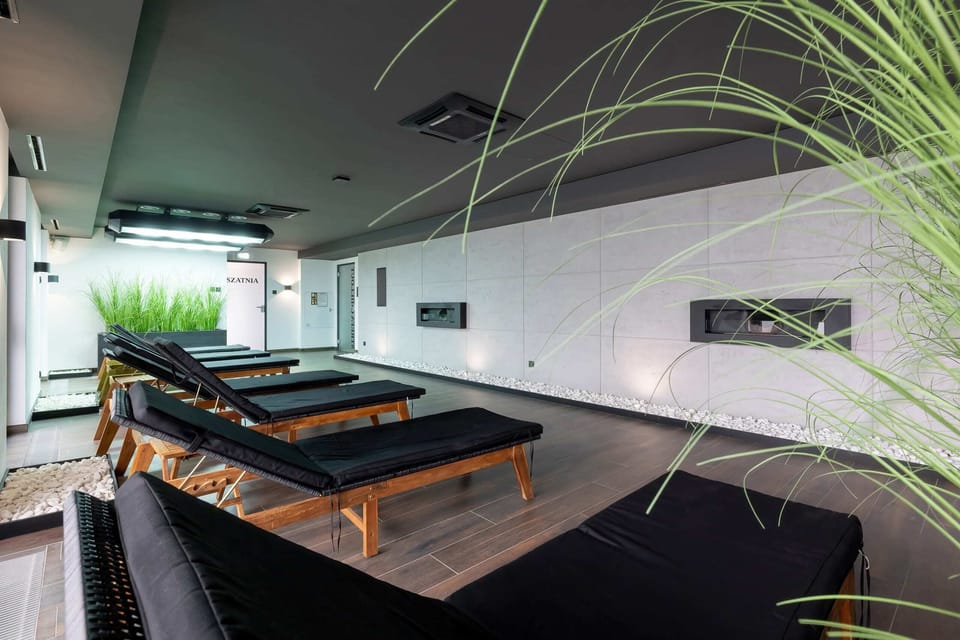 A spacious and modern relaxation area with sun loungers and stylish décor and green plants.