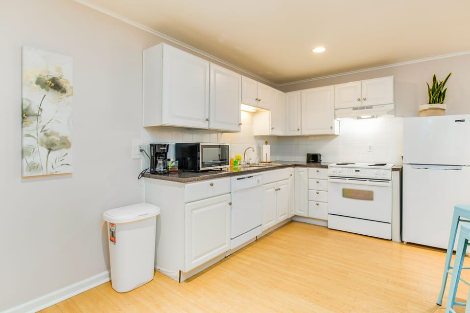 The kitchen has an electric stove, microwave, dishwasher, and refrigerator for your convenience.