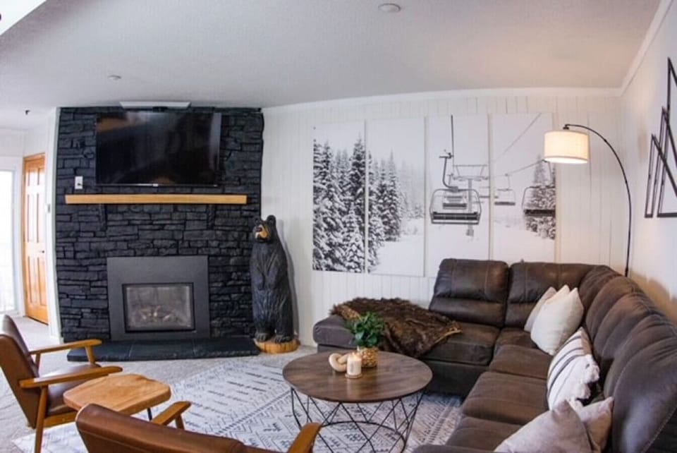 Cozy large sectional with pull out queen size sleeper. Mid century arm chairs around coffee table. Warm gas fireplace with real wood mantle. 55 inch smart Roku TV. Many streaming service options. Beautiful mountain art on the walls.