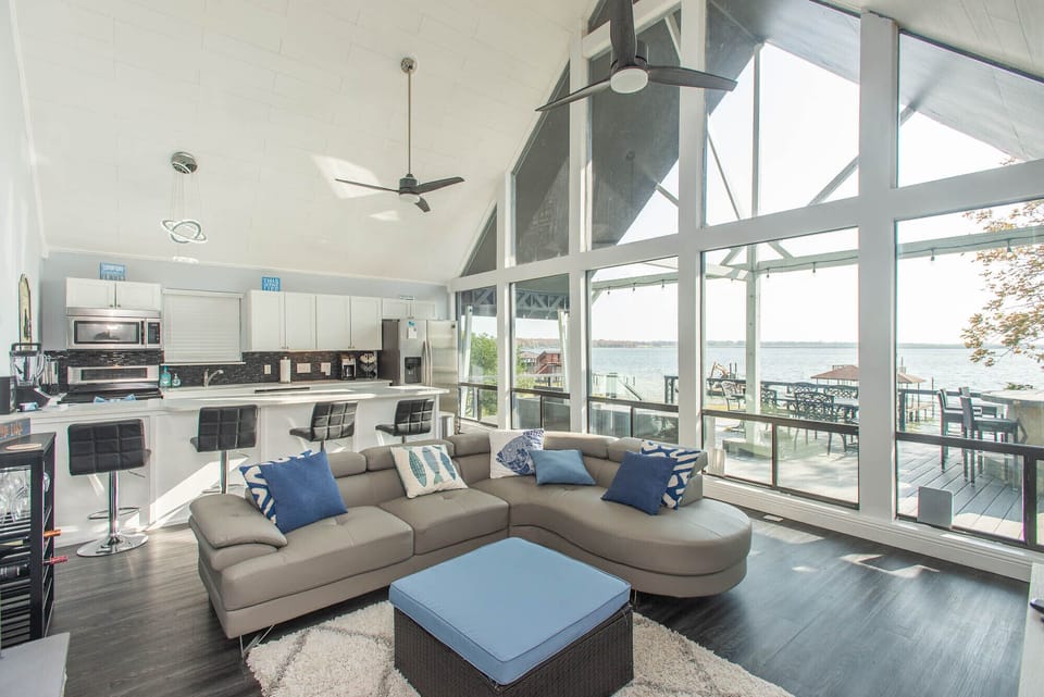 The great room of this A-frame home features a wall of windows with lake views!