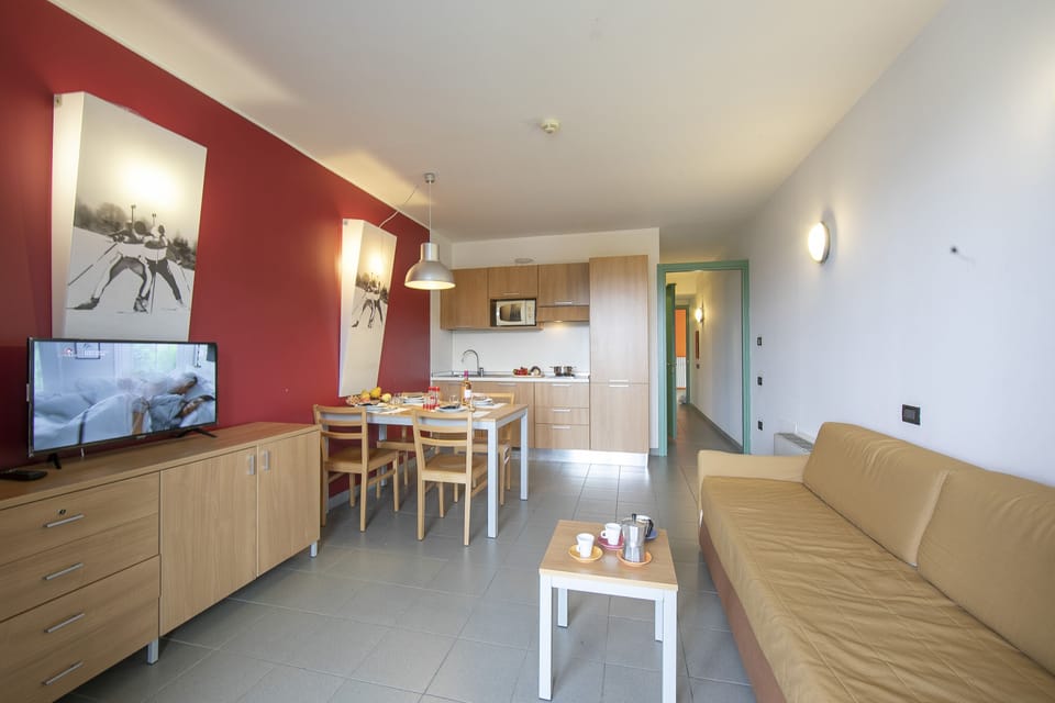 living area with sofa bed and view of kitchen and corridor