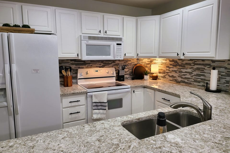 Kitchen with microwave, oven, refrigerator and dishwasher.
