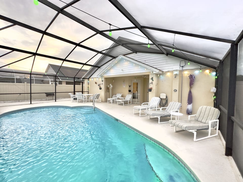 1 outdoor table, lounge chairs, and an outdoor shower in the pool area. 