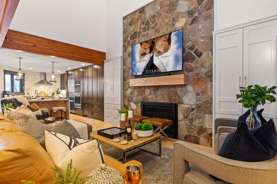 Living Room with leather sectional/sofa sleeper, arm chairs, gas fireplace, and 75" Smart TV