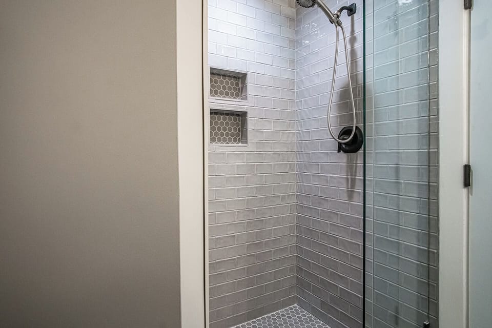 Full bathroom in main living space featuring a walk-in shower.