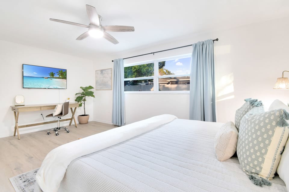 Bright and airy master bedroom with a view of the backyard.