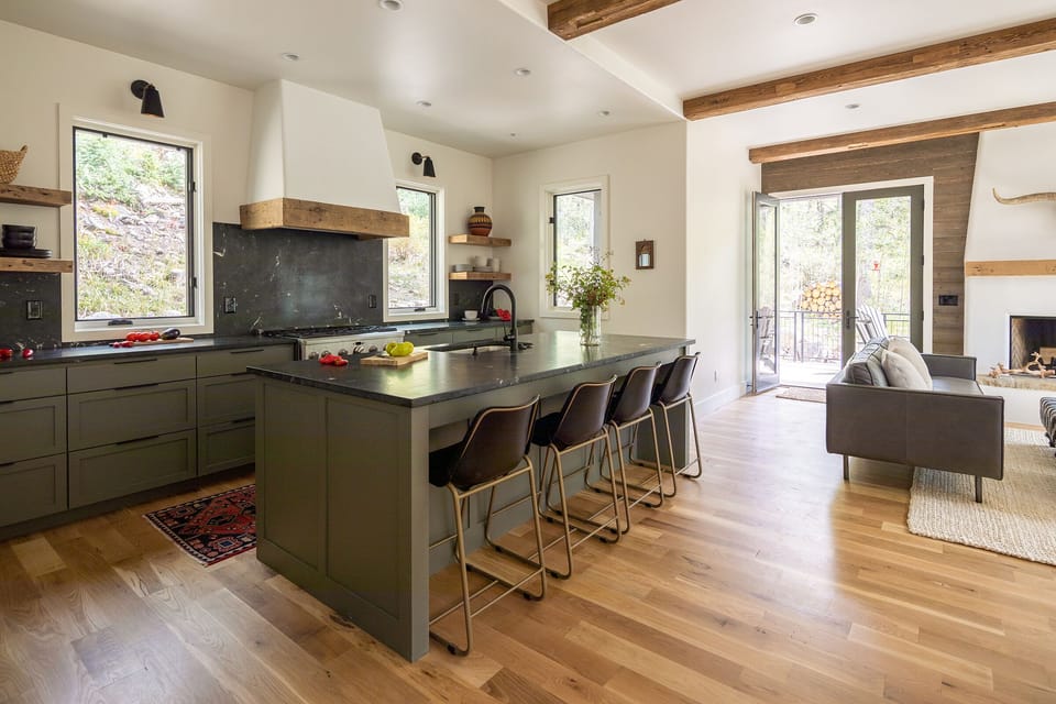 Elegant and user friendly kitchen with 6 burner range, hood and ample storage with comfortable bar seating for social meal prep.