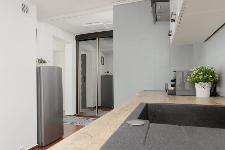 A modern kitchen with white cabinets, ample countertop space, and equipped with all necessary appliances.