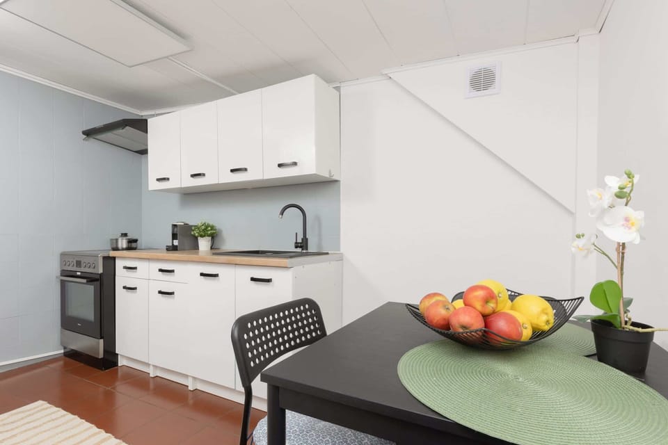 A modern kitchen with white cabinets, ample countertop space, and equipped with all necessary appliances.
