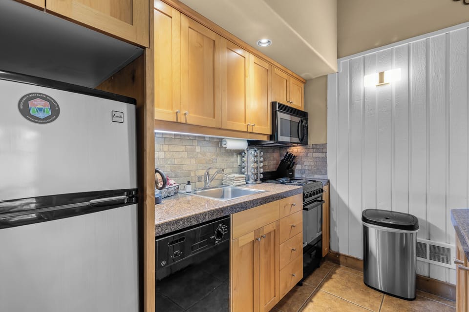 Your fully equipped kitchen features warm wood cabinetry, granite countertops, and modern appliances ready for your culinary adventures. Bright and inviting, it's a perfect space to prepare home-cooked meals during your stay.