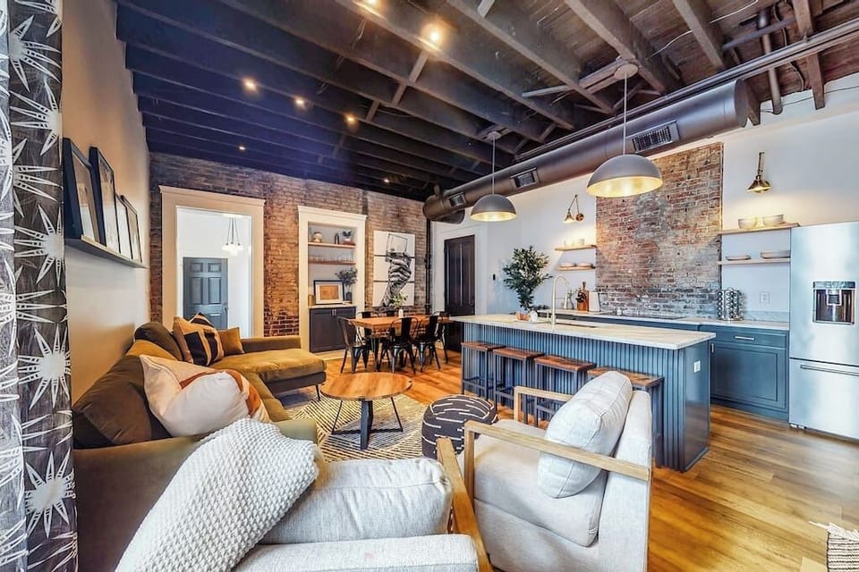 Living Room: The rustic modern design adds warmth to the room, featuring a large sofa, two spacious couches, and a comfy bean bag.