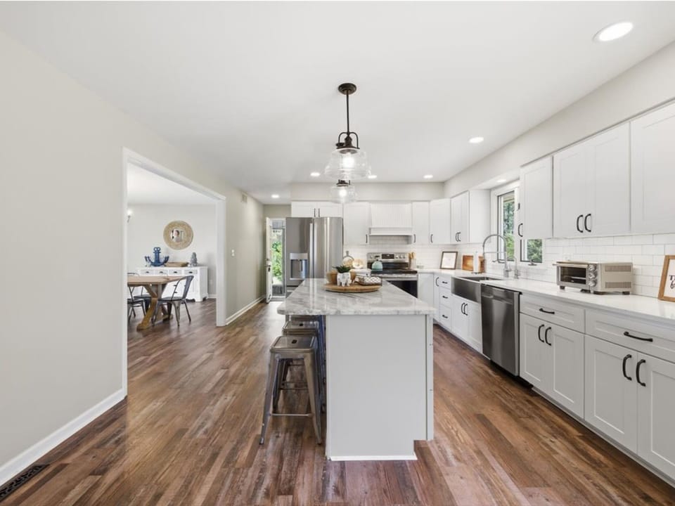 Step into your fully equipped gourmet kitchen with sleek white cabinetry, stainless appliances, and a spacious island perfect for gathering, cooking, and making memories together.