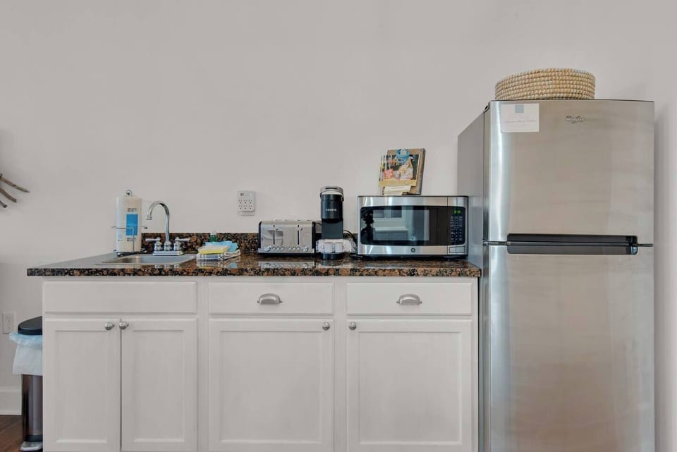 This condo has a kitchenette. There is a full size fridge, microwave, toaster, blender, plates, coffee mugs, and silverware. 