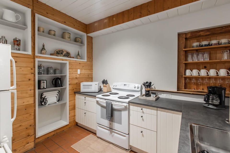 Fully-stocked kitchen with a fridge, stove/oven and microwave