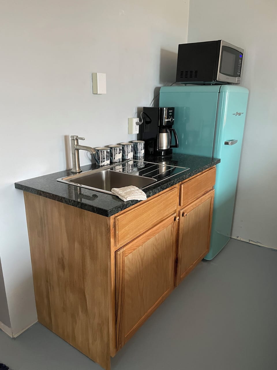 Fully appointed kitchenette with mid-sized refrigerator and place settings

