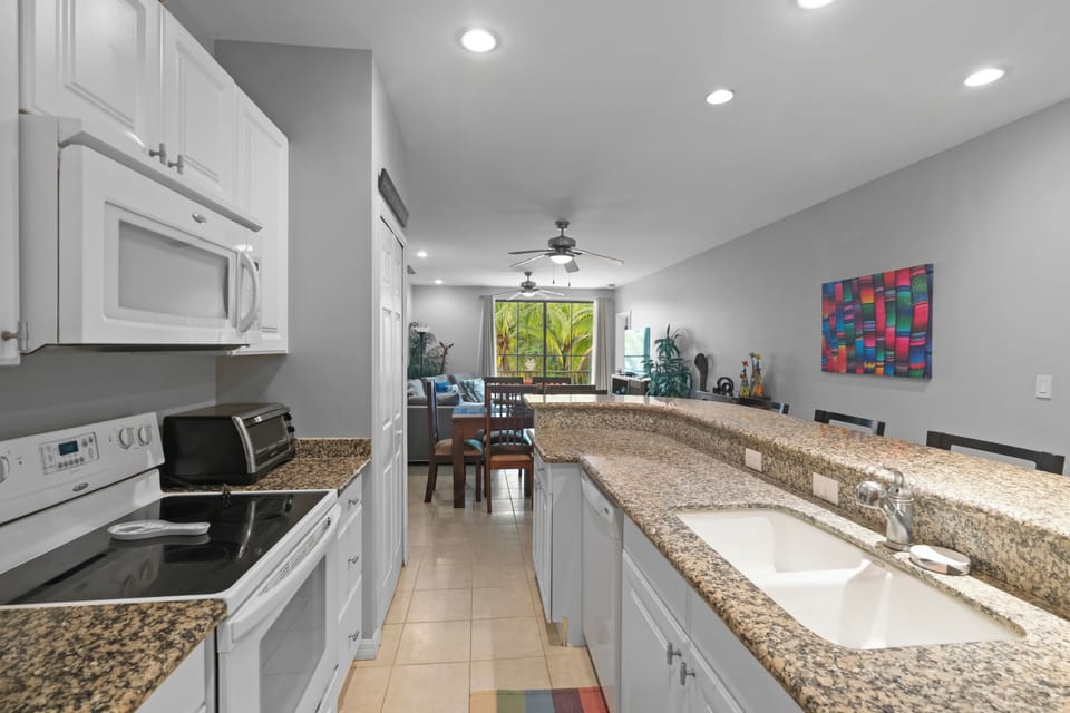 The fully equipped kitchen features full-size appliances, including a fridge, stove, dishwasher, and a stacked washer/dryer (tucked away in the closet)