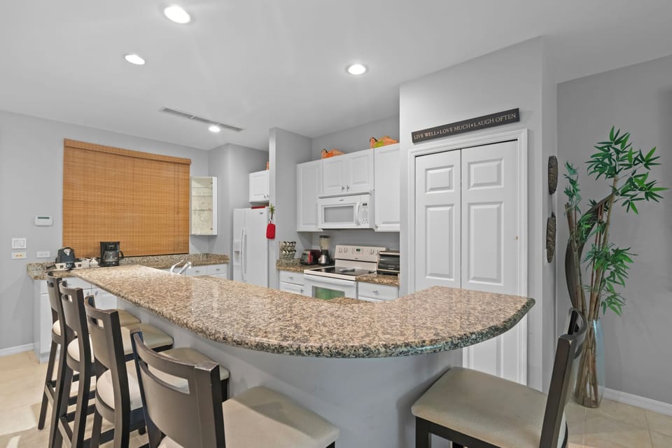 The fully equipped kitchen features full-size appliances, including a fridge, stove, dishwasher, and a stacked washer/dryer (tucked away in the closet)