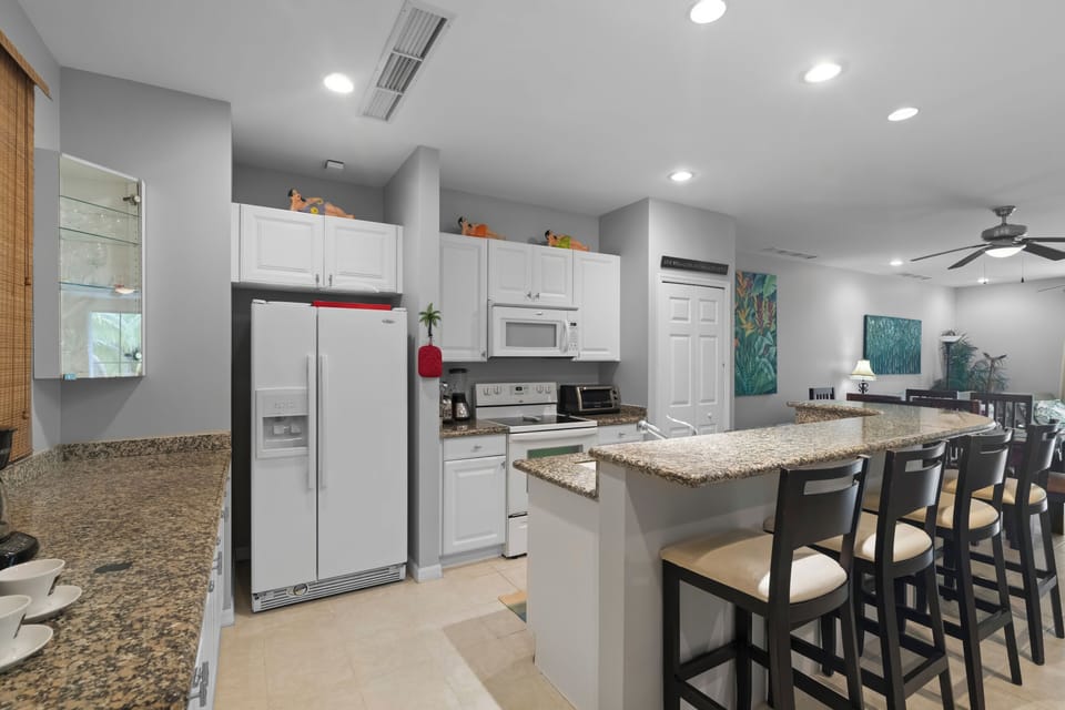  The fully equipped kitchen features full-size appliances, including a fridge, stove, dishwasher, and a stacked washer/dryer (tucked away in the closet)