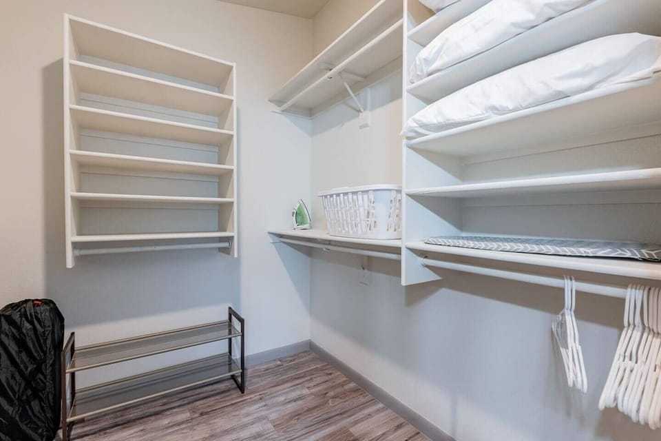 Primary walk in closet - iron, hangers, laundry basket provided, pack n play