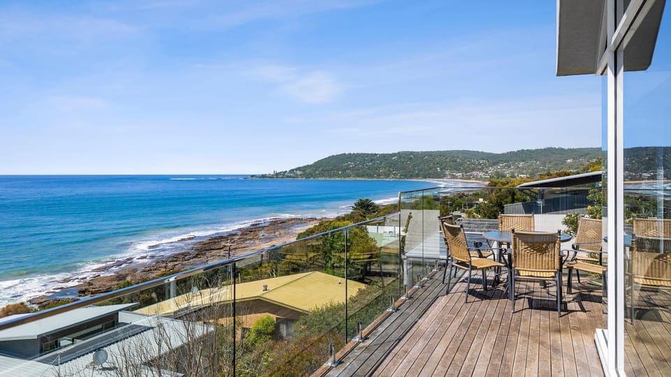 A deck with outdoor furniture where you can take in the breathtaking views of the beach's azure waters crashing on the rocky coastline. 