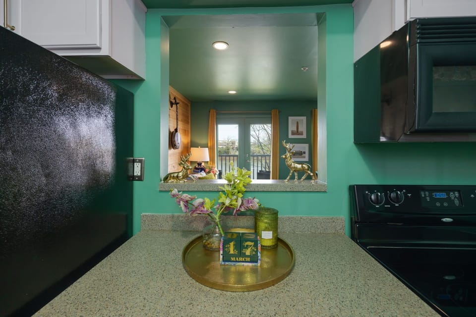 An inviting kitchen featuring trendy green walls contrasted with sleek black appliances, creating a modern and stylish ambiance. 🌿 #KitchenGoals