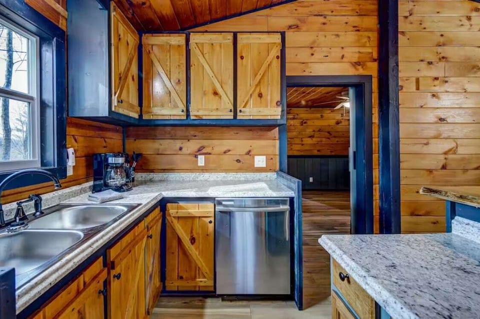 The kitchen is fully stocked with a dishwasher, coffee maker, utensils, plates, cups, mugs, and more.
