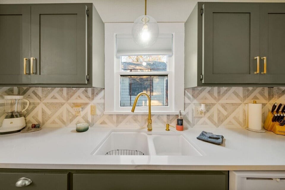 A deep farmhouse sink gives you plenty of room to wash (or hide) dishes during your stay.  A new blender sits in one corner while a knife block is in the other corner.