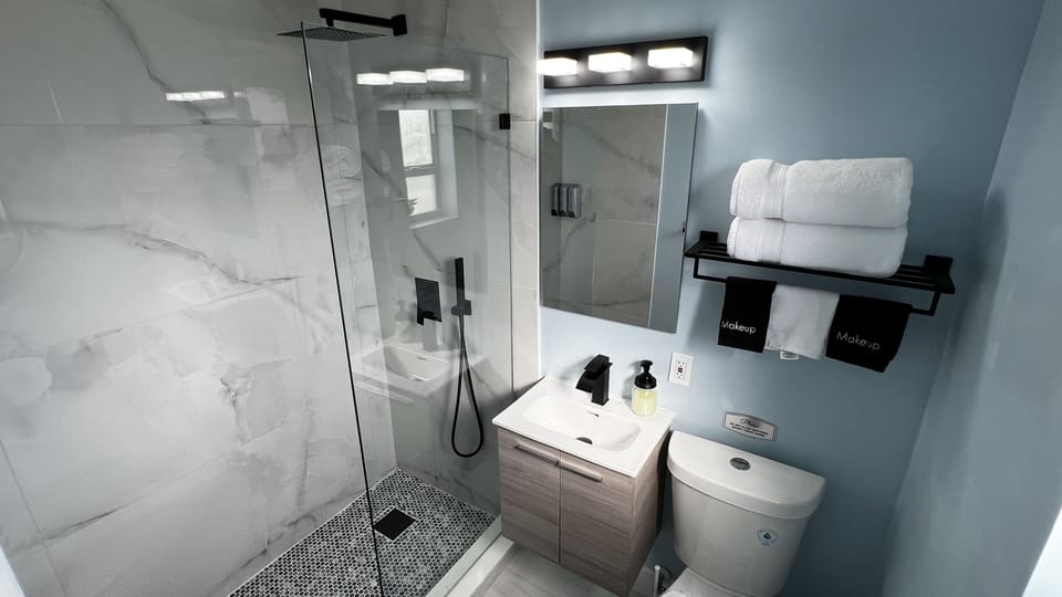 Modern spacious shower with rain shower overhead and Handheld Sprayer