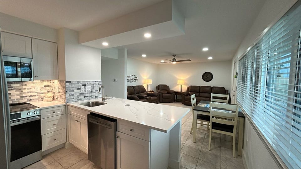 Relax in your modern kitchen featuring gleaming countertops and stainless appliances, while cozy living room seating awaits for evening conversations.