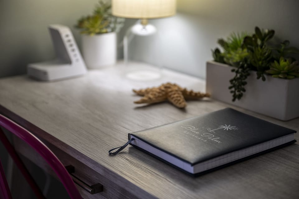 The primary bedroom offers a dedicated desk space, perfect for remote work or planning your next adventure. Stay productive while enjoying a glimpse of paradise just outside your window.