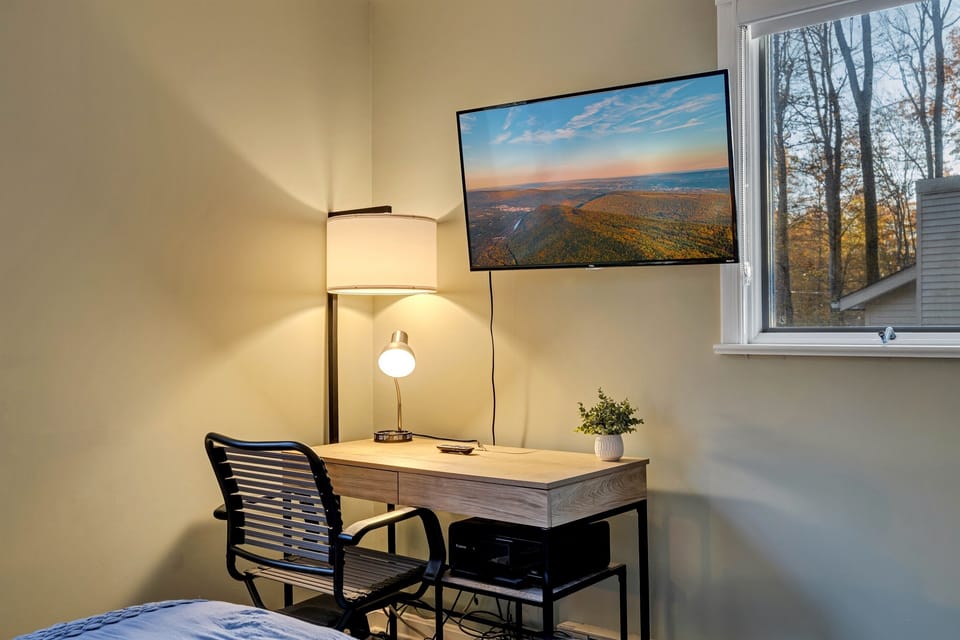Cozy small workspace located in one of the bedrooms, featuring a simple desk and chair, ideal for remote work or quiet study