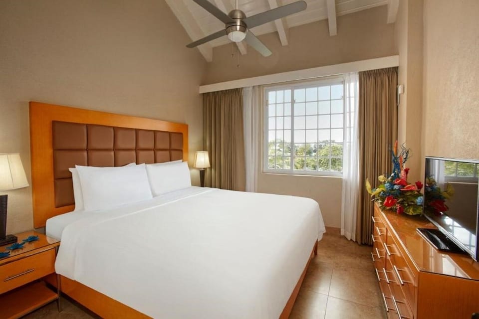 Unwind in crisp linens beneath soaring ceilings and soft light.