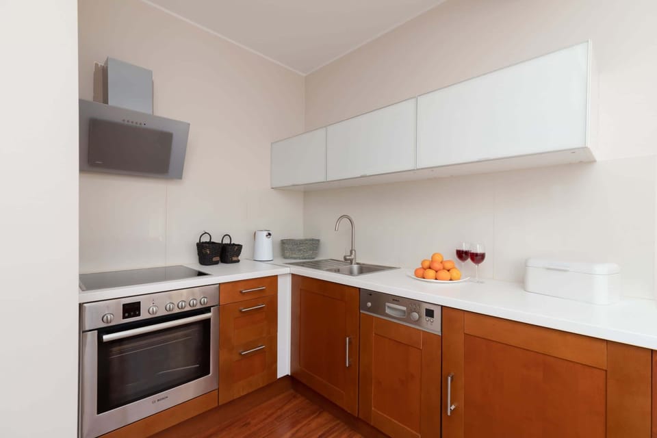 A compact kitchen with white cabinets and wooden countertops, blending functionality with modern aesthetics.