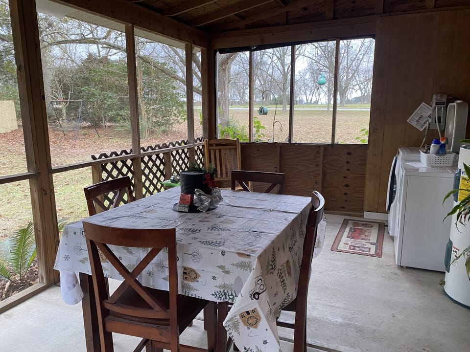 The screen porch. Washer/dryer are located out here. There is also a rocker. 