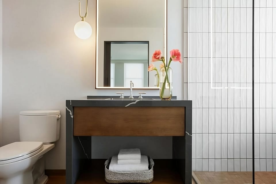Refresh effortlessly with sleek vanity lighting and plush towel storage.