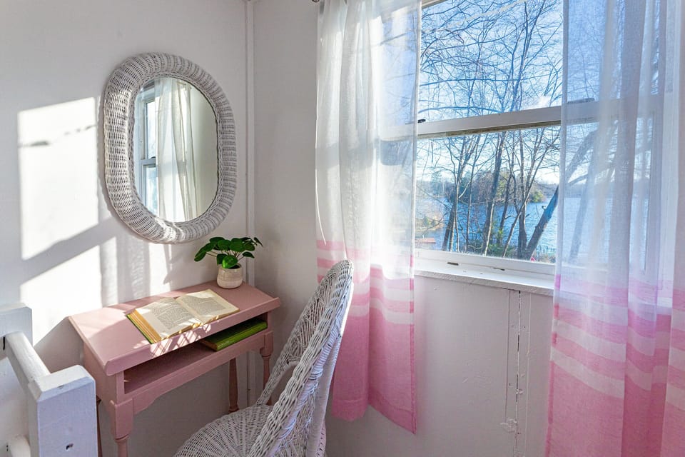 [Bedroom, Upstairs] Sunbeams cascade onto the workstation, illuminating the amazing lakefront water view.