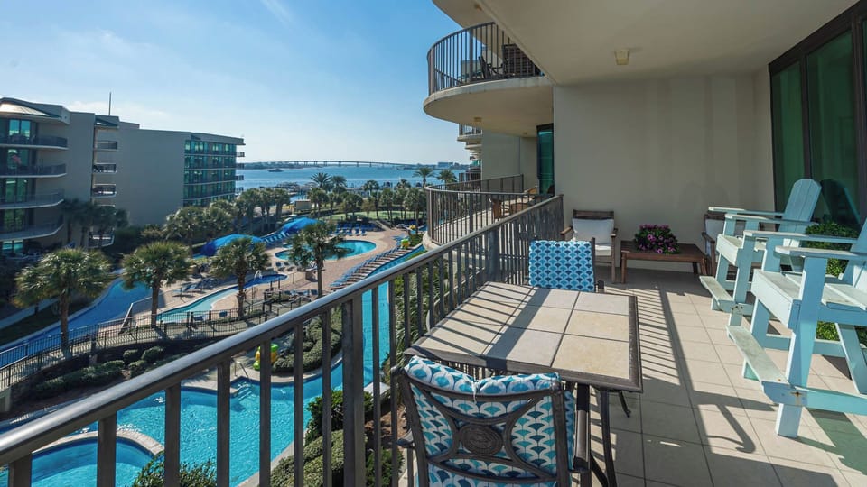 Lounge on the balcony overlooking the refreshing pool, lazy river, stunning bay water, and marina activity
