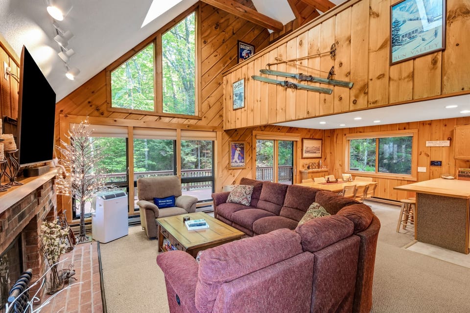Main floor vaulted living space with expansive windows and fireplace