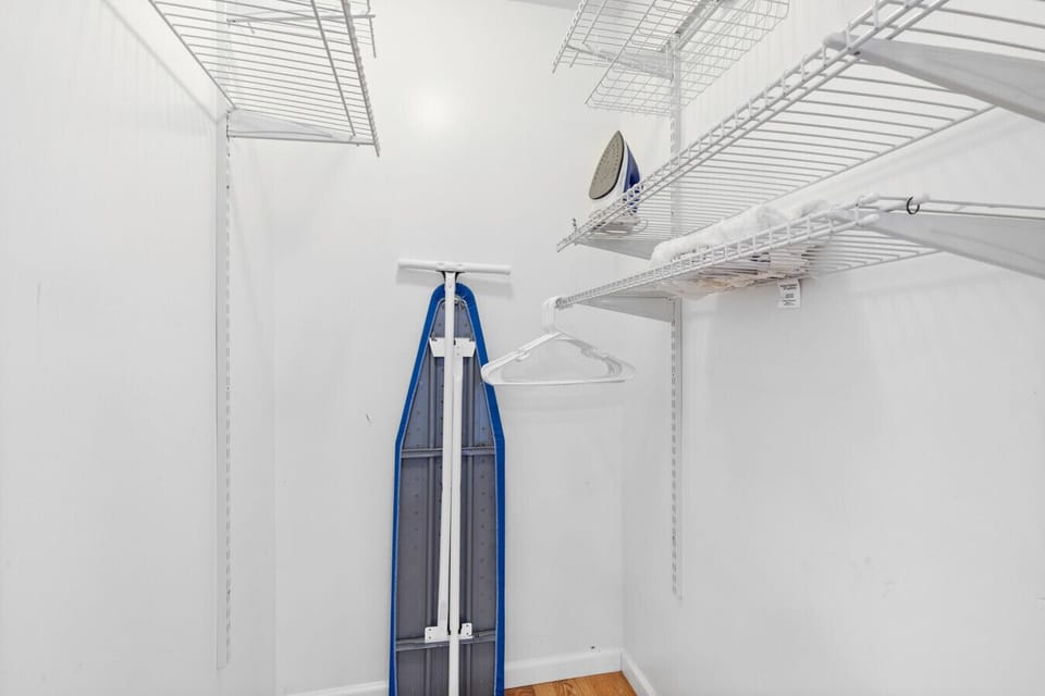 Main floor walk-in closet with iron and ironing board