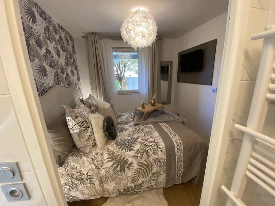 Vue depuis la salle de bain vers la chambre, TV murale et sèche-serviettes