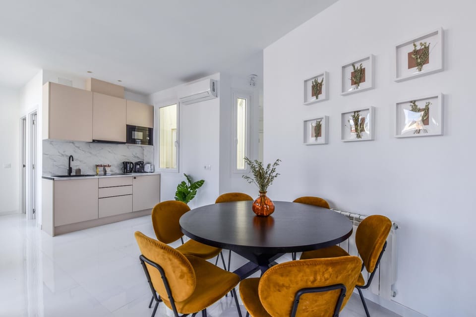View of the dining area with round table for 6 people and background kitchen