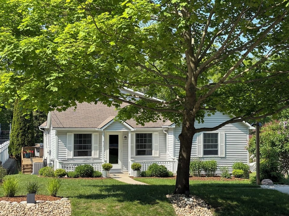 EXTERIOR:  The front of the house in summer.