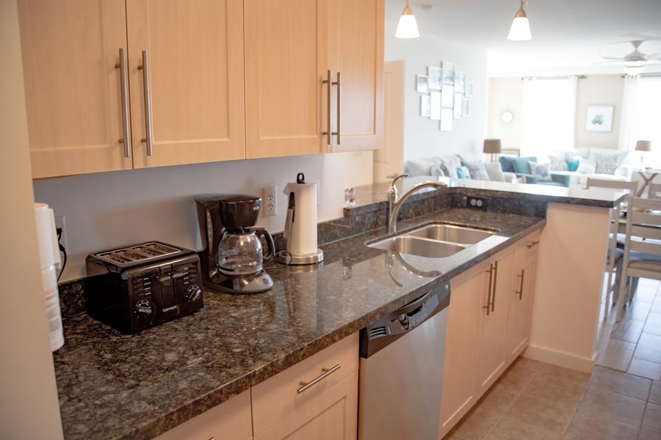 Well stocked kitchen with granite countertops and stainless steel appliances.