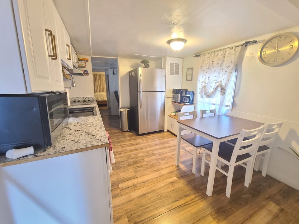 microwave, kitchen visible, indoor, kitchen, refrigerator, stovetop,dining table