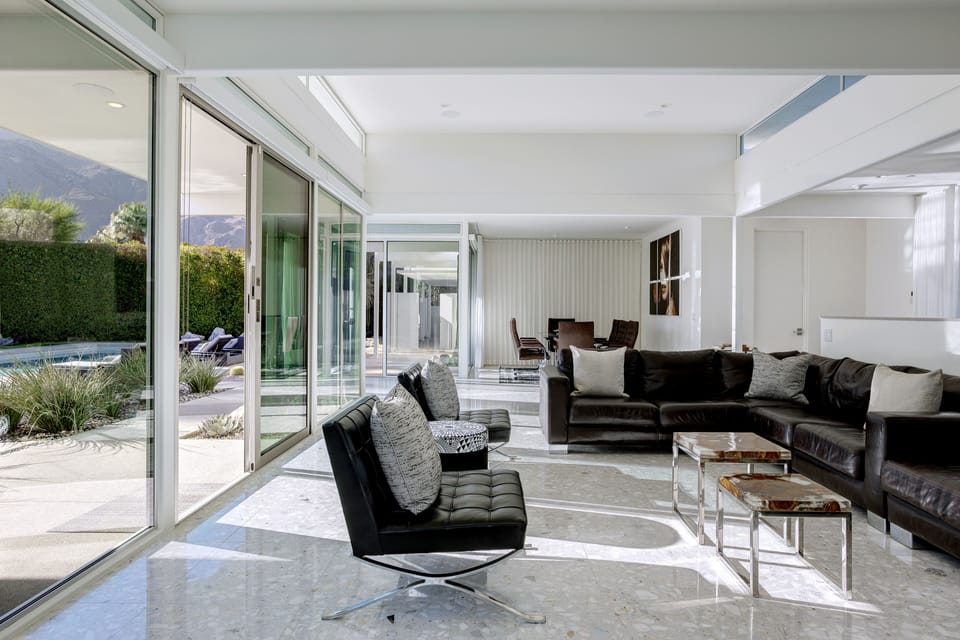 Open-concept living and dining areas, with wall-to-wall glass + views.