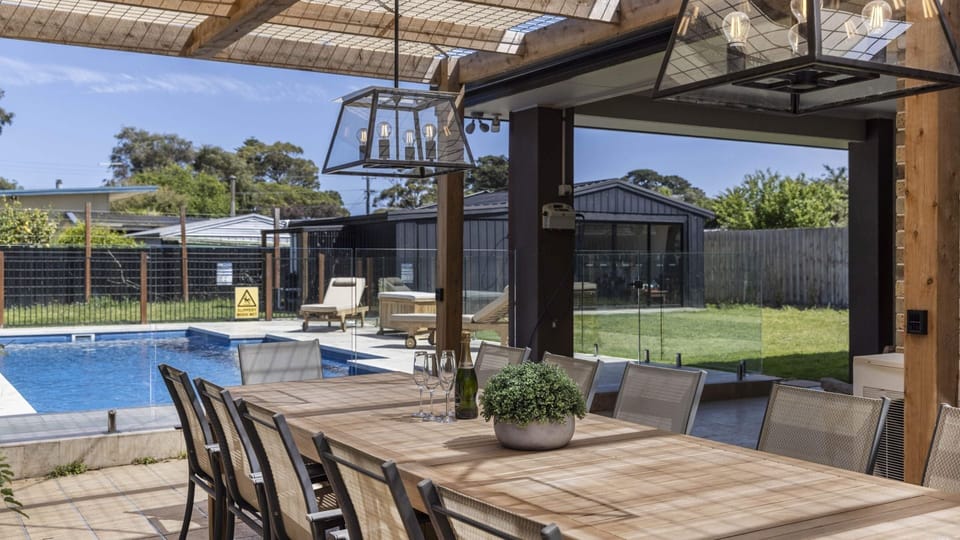 Outdoor dining overlooking pool and fully fenced garden area