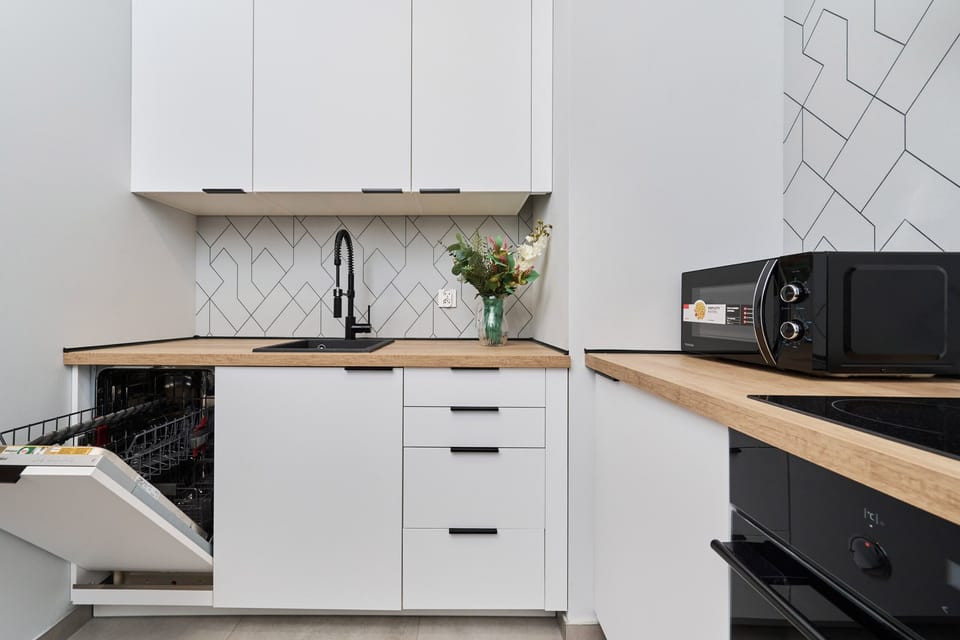 Kitchenette with plenty of kitchen utensils and dishes. 